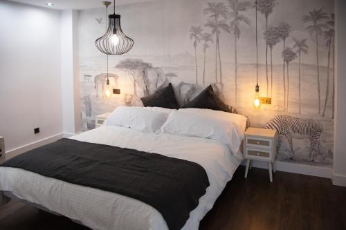 ein Schlafzimmer mit einem großen Bett und einem Gemälde an der Wand in der Unterkunft Apartamentos Boutique Cervantes in Plasencia