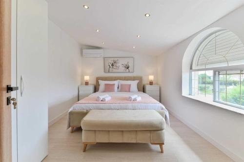 - une chambre blanche avec un grand lit et une fenêtre dans l'établissement Luxury Villa Maria with large pool, à Suhovare