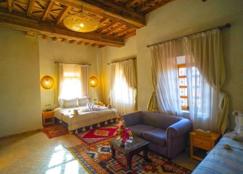 a living room with a bed and a couch at Kasbah Hnini in Igdourane