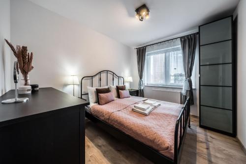 Schlafzimmer mit einem Bett, einem Schreibtisch und einem Fenster in der Unterkunft Rent like home - Browary Wrocławskie in Breslau