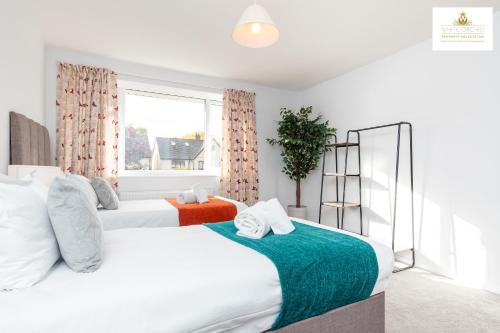 a bedroom with two beds and a window at 3 Bedroom House in Stevenage By White Orchid Property Relocation Free Paring Wi-Fi Serviced Accommodation in Stevenage