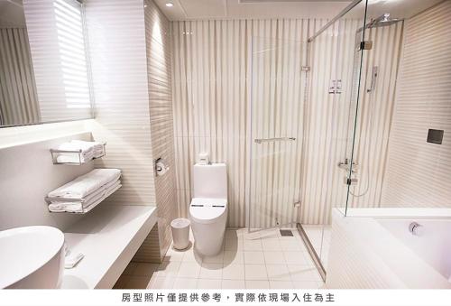 y baño con ducha, aseo y lavamanos. en Royal Group Hotel Minghua Branch, en Kaohsiung