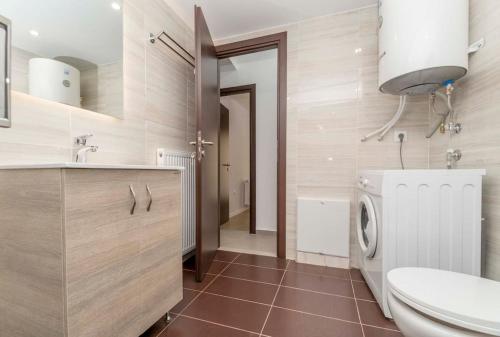 a bathroom with a toilet sink and a washing machine at [Bonni] - Central apt, 2' from metro station #11 in Athens