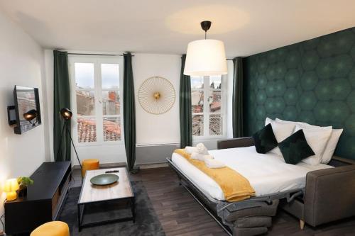 une chambre avec un grand lit avec une tête de lit verte dans l'établissement N3 des Études Duplex Hypercentre Wifi ConciergerieDameCarcas, à Carcassonne