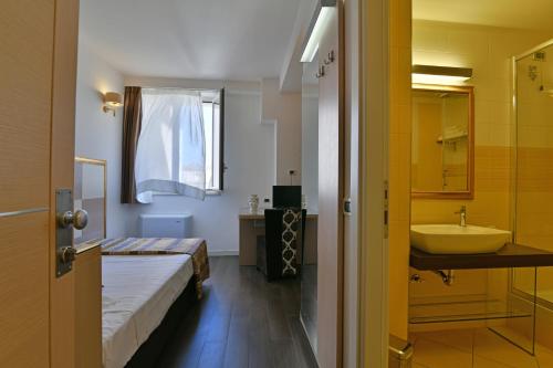 uma casa de banho com uma cama, um lavatório e uma banheira em Hotel Le Chevalier em Taormina