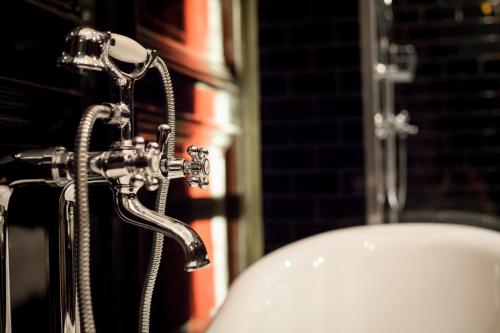 a bathroom with a faucet next to a sink at The Museum - Au Lit, Jérôme! in Antwerp