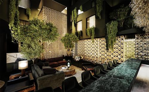 a lobby with a table and chairs and plants at Magic Hotel & Apartments Kløverhuset in Bergen