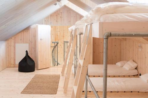 a bedroom with bunk beds in a room with wooden walls at The Longhouse at Lista in Farsund