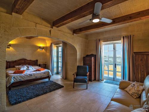 1 dormitorio con 1 cama y 1 silla en una habitación en Hanini Holiday Home en Qala