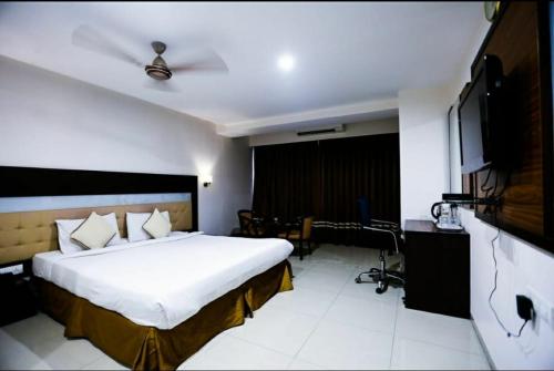 a hotel room with a bed and a television at Hotel Sitara Grand L.B. Nagar in Hyderabad