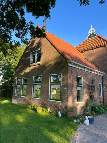 a brick house with an orange roof at BnB Alde Hiemen Friesland in Terwispel
