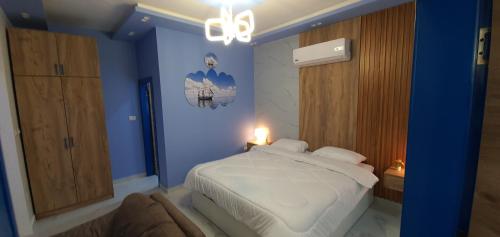 a blue bedroom with a bed and a chandelier at Santorini Breeze Chalet in Amman