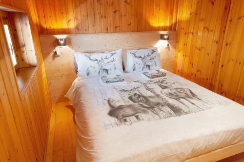 a bed with a drawing of a deer on it at Sweet Somma Mountain Lodge 2 in San Guglielmo