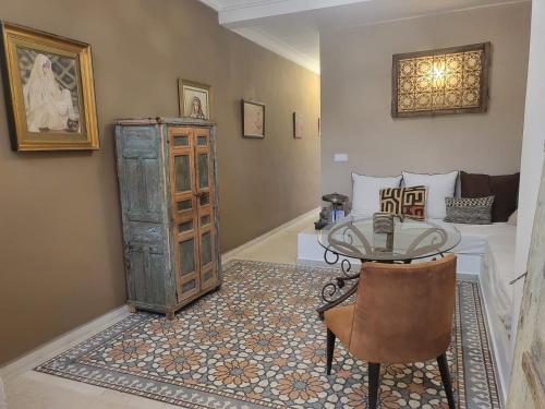 a dining room with a table and a bedroom at Riad Home Zemrane in Marrakesh