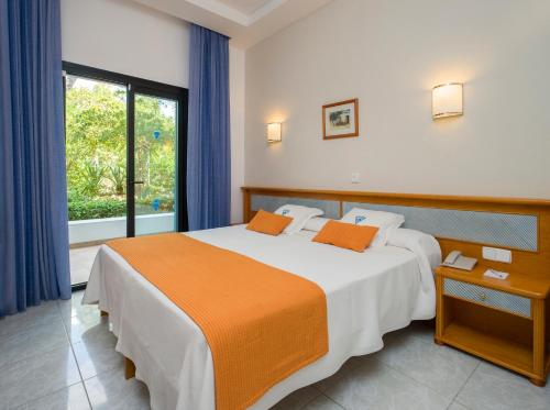 a bedroom with a large bed and a window at Hotel Osiris Ibiza in San Antonio