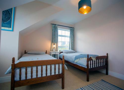 1 dormitorio con 2 camas y ventana en Saltee View Holiday Home en Kilmore