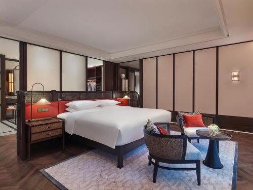 a bedroom with a bed and a table and chairs at Andaz Xiamen, By Hyatt in Xiamen