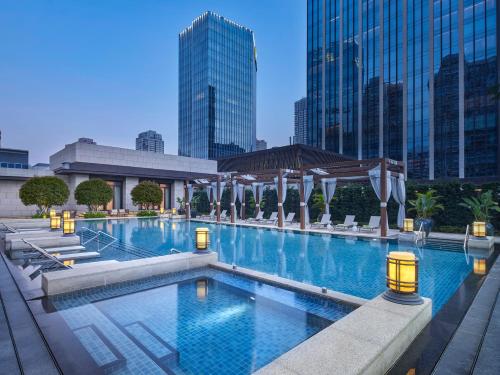 a large swimming pool in a city with tall buildings at Andaz Xiamen in Xiamen