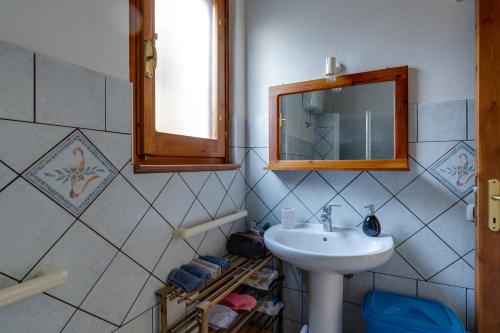 La salle de bains est pourvue d'un lavabo et d'un miroir. dans l'établissement Samarighouse, à Putzu Idu
