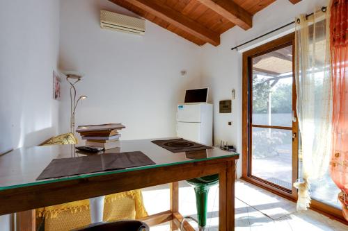 a kitchen with a desk with a stove and a window at Samarighouse in Putzu Idu