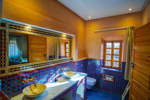 a bathroom with a sink and a toilet and a mirror at Kasbah Hnini in Igdourane