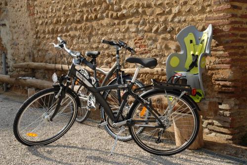 VidouzeにあるA la Vie Douceのレンガの壁の隣に2台の自転車が停まっています