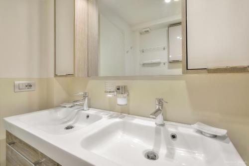 Baño blanco con 2 lavabos y espejo en Appartamento Conte Verde 1756 - Storie e Dimore, en Turín