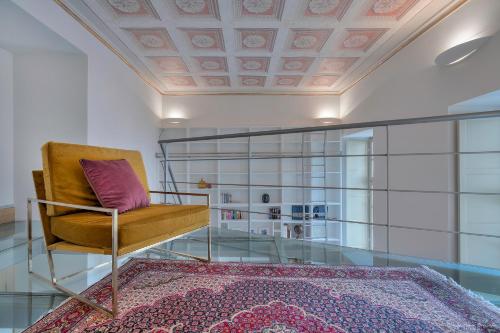 sala de estar con silla y alfombra en Appartamento Conte Verde 1756 - Storie e Dimore en Turín