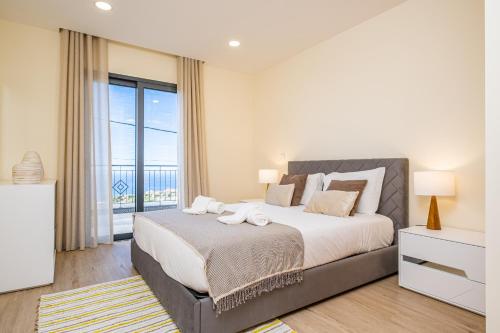 1 dormitorio con cama grande y ventana grande en Canhas Residence I by Madeira Sun Travel en Ponta do Sol