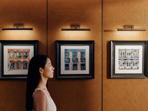 a woman looking at art on a wall at Andaz Xiamen, By Hyatt in Xiamen
