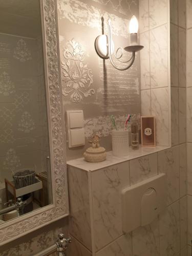 ein Badezimmer mit einem Spiegel und einem Waschbecken in der Unterkunft Stillvolle Designwohnung im historischen Zentrum in Stolberg i. Harz