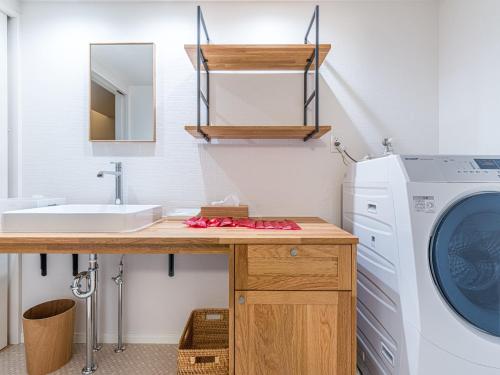 ein Badezimmer mit einer Waschmaschine und einem Waschbecken in der Unterkunft Rakuten STAY HOUSE x WILL STYLE Itoshima 101 in Itoshima