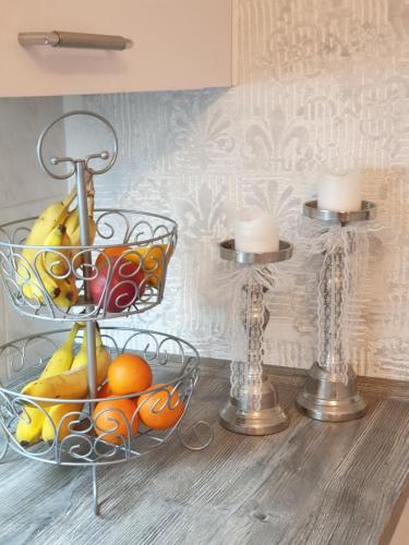 a table with two baskets of fruit and candles at Stillvolle Designwohnung im historischen Zentrum in Stolberg i. Harz