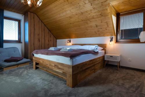 1 dormitorio con 1 cama en una habitación con paredes de madera en TATRYSTAY Family Villa Rosa, en Stará Lesná