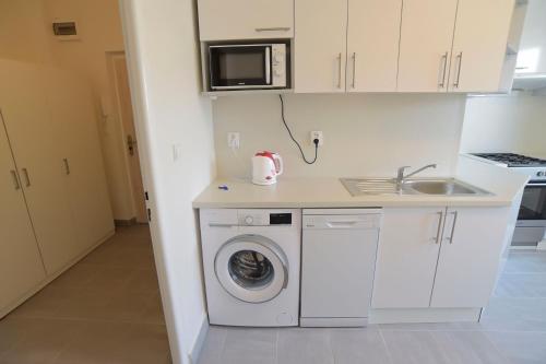 a kitchen with a washing machine and a sink at Apartmány Karviná in Karviná