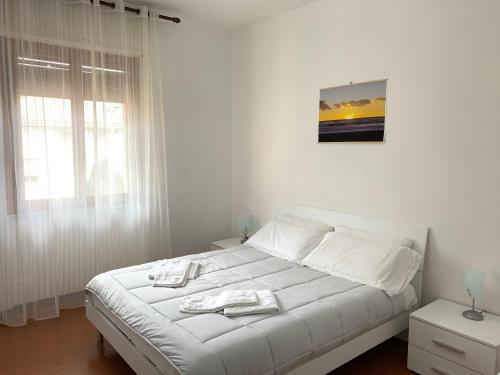 a white bed with two towels on it in a bedroom at Elisa Appartamento con parcheggio in Levanto