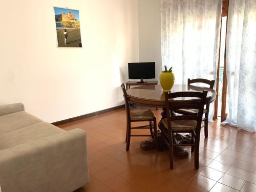 a living room with a table with chairs and a television at Elisa Appartamento con parcheggio in Levanto