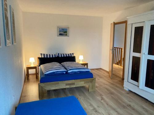 a bedroom with a blue bed with two pillows on it at Ferienwohnung Thomsen in Tarp