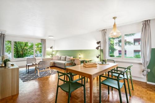 uma sala de estar com uma mesa e cadeiras e um sofá em Beautiful Boutique Apartment DRAHTZUG8 em Zurique