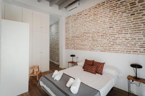 una camera da letto con un muro di mattoni e un letto di O&L Puñonrostro Bright Minimalist Central Home a Siviglia