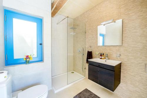 a bathroom with a toilet and a sink and a mirror at Ta Rena Holiday Home in Nadur