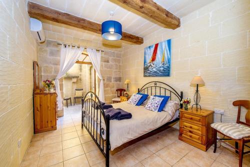 a bedroom with a bed and a table and a chair at Ta Rena Holiday Home in Nadur