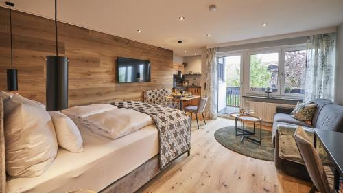 Un dormitorio con una cama grande y una sala de estar. en Chalet Alpenruhe, en Oberstaufen