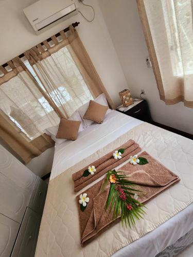 a bedroom with a white bed with flowers on it at Kaz Memel in Beau Vallon