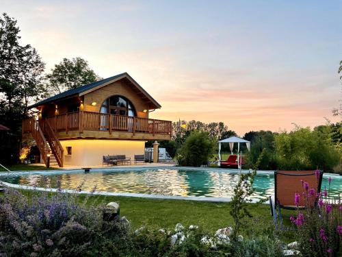 a house with a deck over a swimming pool at Hôtel du Domaine de La Grange de Condé in Condé-Northen