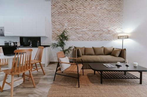 un soggiorno con divano, tavolo e sedie di O&L Puñonrostro Bright Minimalist Central Home a Siviglia