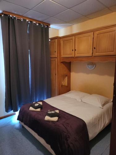 1 dormitorio con 1 cama con 2 toallas en Le Clos Fleuri, en Bourg-de-Thizy