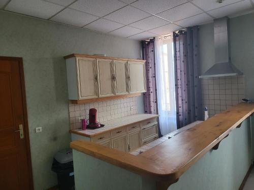 eine Küche mit einer hölzernen Arbeitsplatte in einem Zimmer in der Unterkunft Le Clos Fleuri in Bourg-de-Thizy