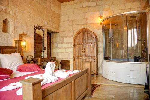 a bedroom with a bath tub and a bed and a tub at Efendi Cave Hotel in Urgup