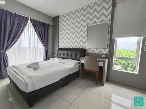 a bedroom with a bed and a table and a chair at JOMSTAY Majestic Ipoh Suites in Ipoh